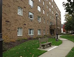a bench is sitting in front of a brick building