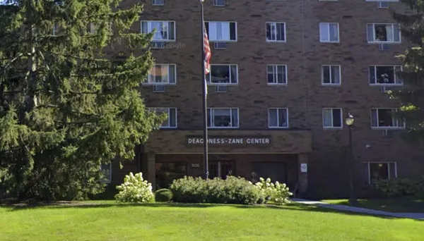 front view of a brick house with a yard