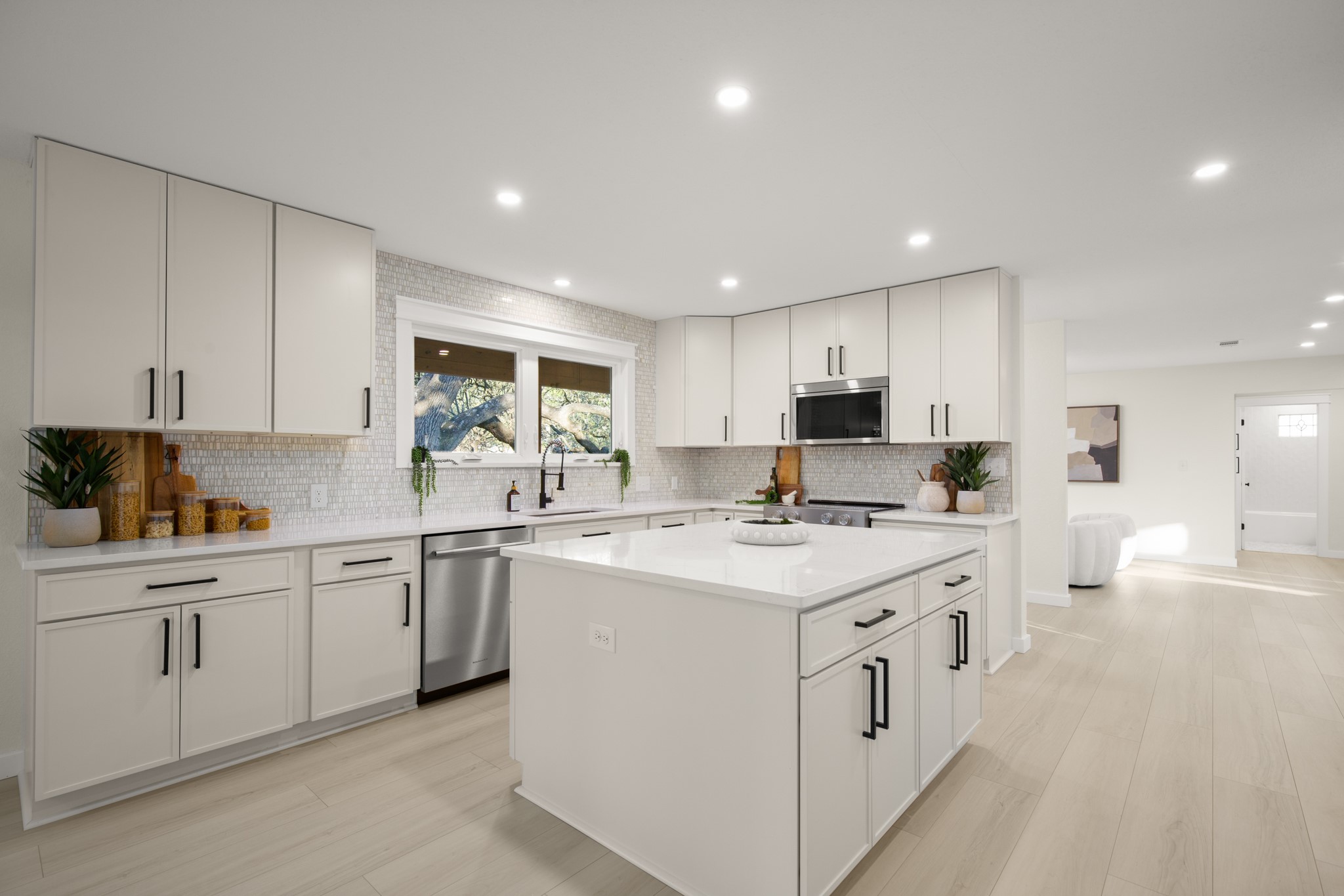 a kitchen with white cabinets appliances and sink