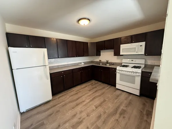 a kitchen with stainless steel appliances granite countertop a stove a sink and a refrigerator