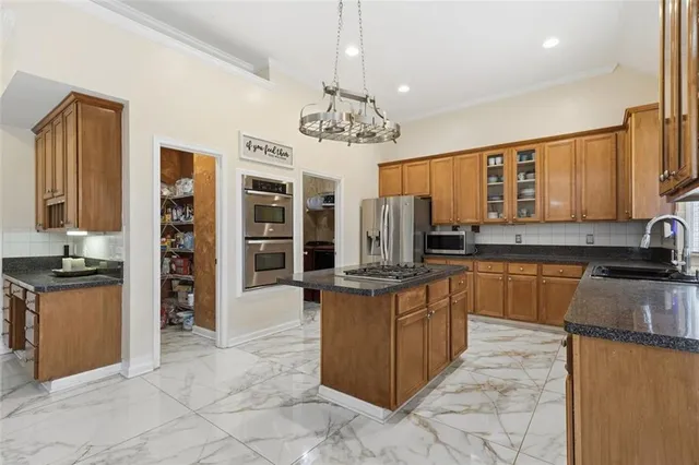 a kitchen with stainless steel appliances granite countertop a sink refrigerator and cabinets