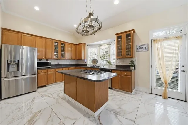 a kitchen with stainless steel appliances granite countertop a stove refrigerator and cabinets