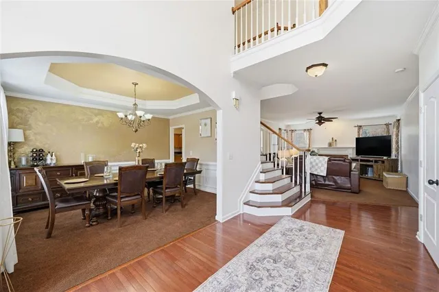 a view of a dining room with furniture a chandelier and wooden floor