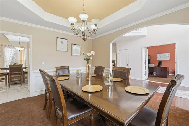 a view of an empty room with wooden floor and a bathroom