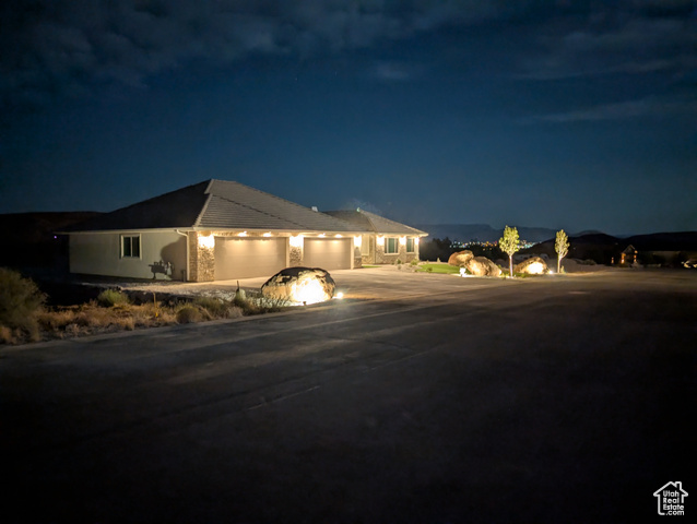 230 Boulder Way Leeds, UT 84746 - Photo 69 of 72 Single story home with a 5+ garage showing two 18' doors, concrete driveway and exterior night lighting