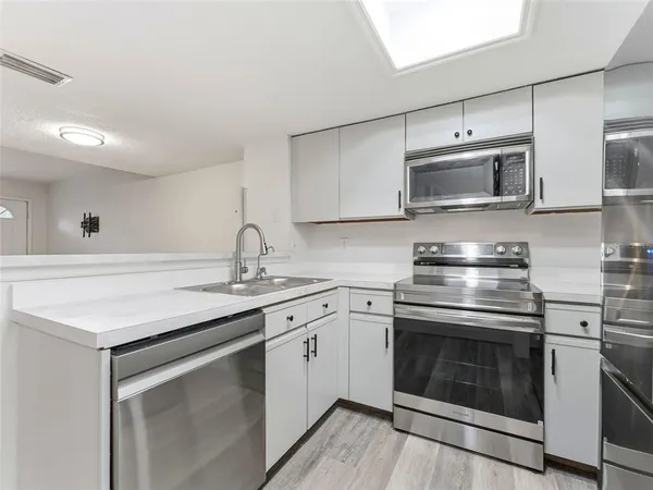 a kitchen with stainless steel appliances granite countertop a sink stove and microwave