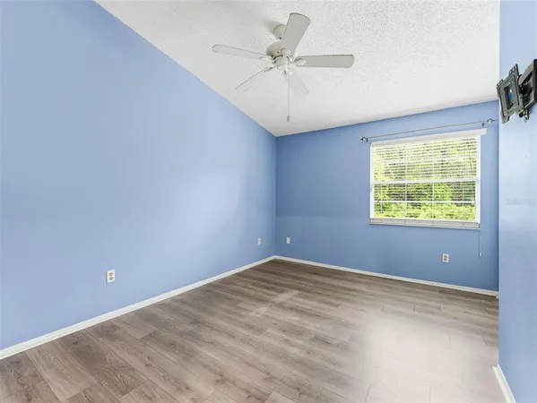 an empty room with windows and fan
