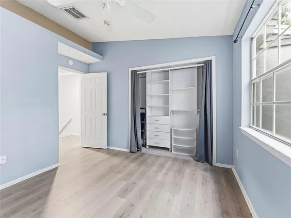 an empty room with closet and windows