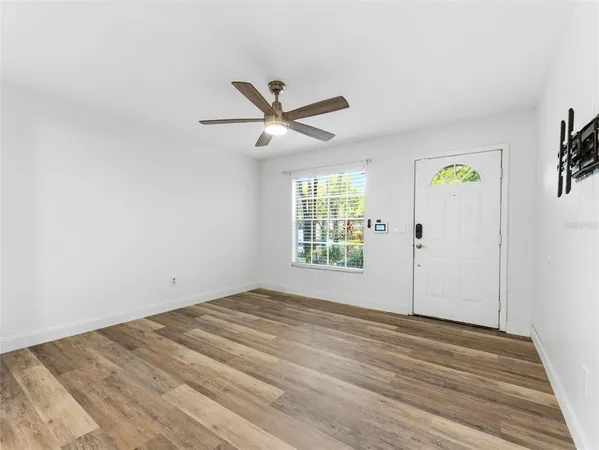 an empty room with windows and fan