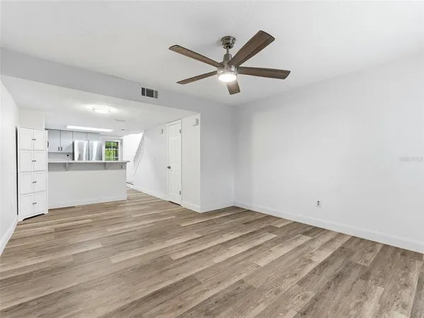 a view of a livingroom with wooden floor and a ceiling fan