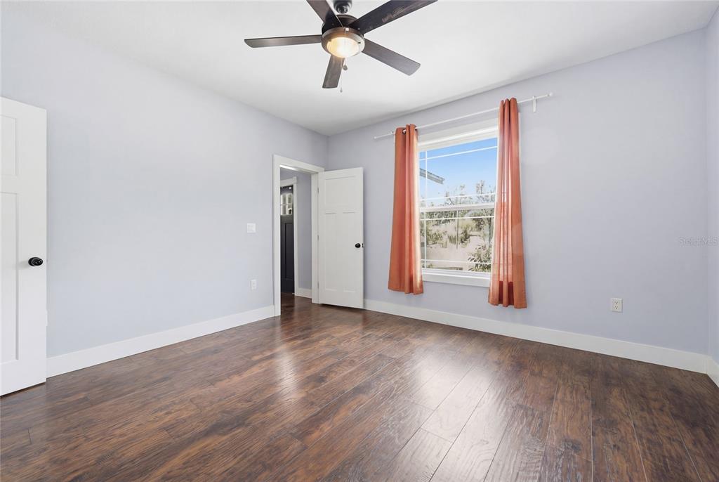 403 Northeast 9th Street Gainesville, FL 32601 - Photo 25 of 62 an empty room with wooden floor chandelier fan and windows