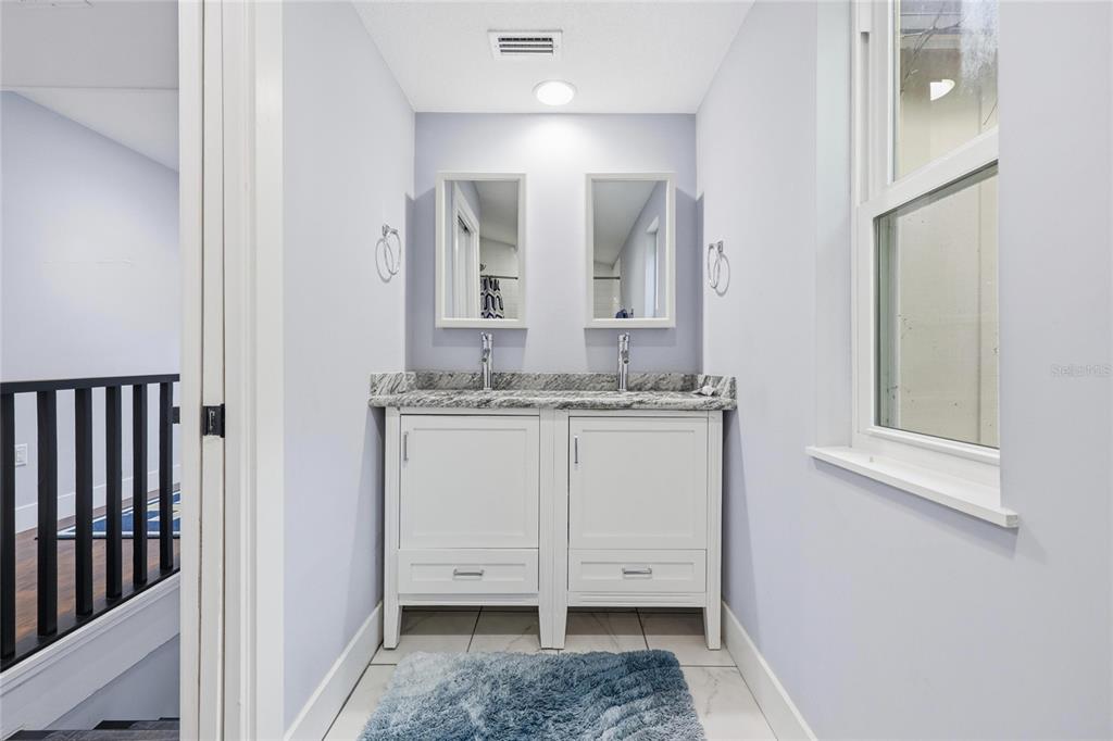 403 Northeast 9th Street Gainesville, FL 32601 - Photo 46 of 62 a bathroom with a granite countertop sink and a mirror