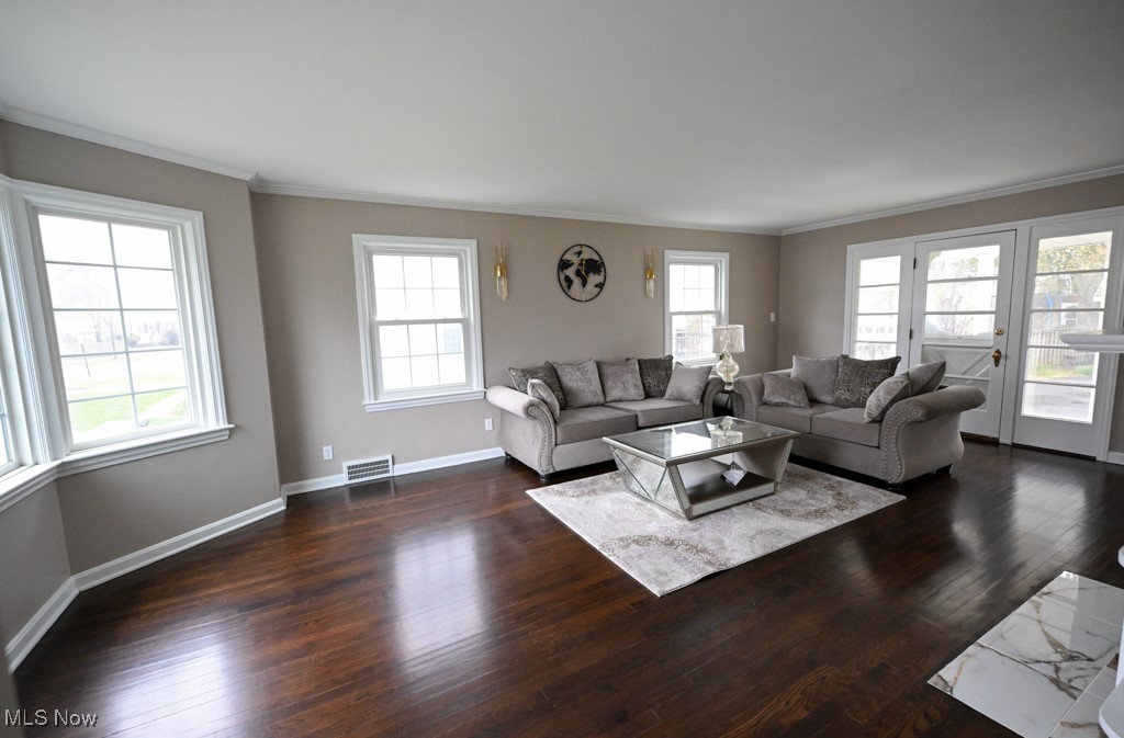 2284 Traymore Road Cleveland, OH 44118 - Photo 5 of 19 Living area with ornamental molding, visible vents, baseboards, and dark wood-style floors