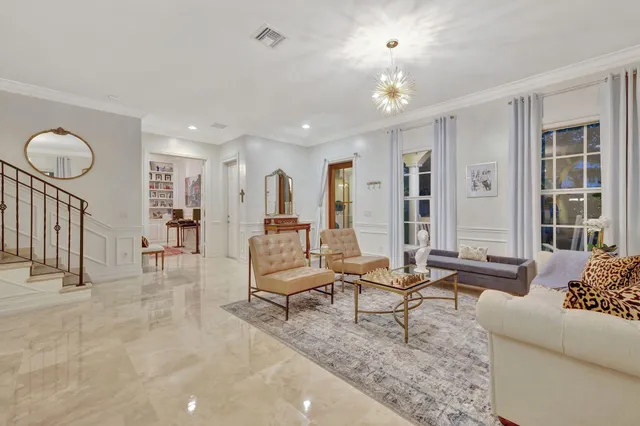 a living room with fireplace furniture and a chandelier