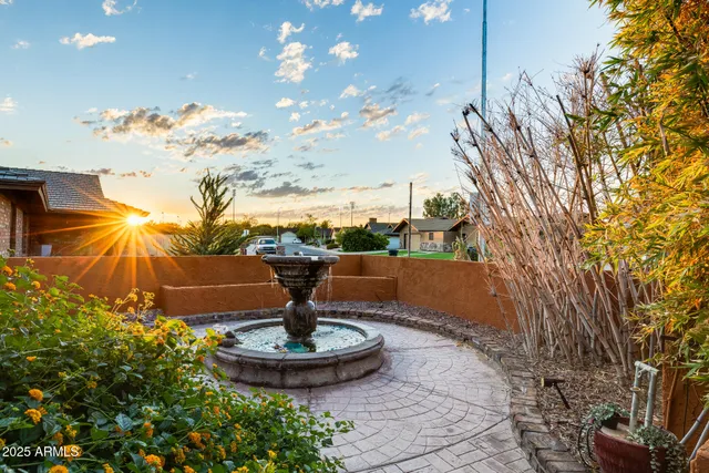a view of a fountain with flower plants