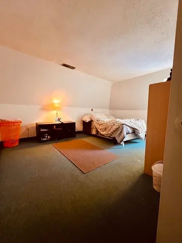 a bedroom with a bed and a lamp