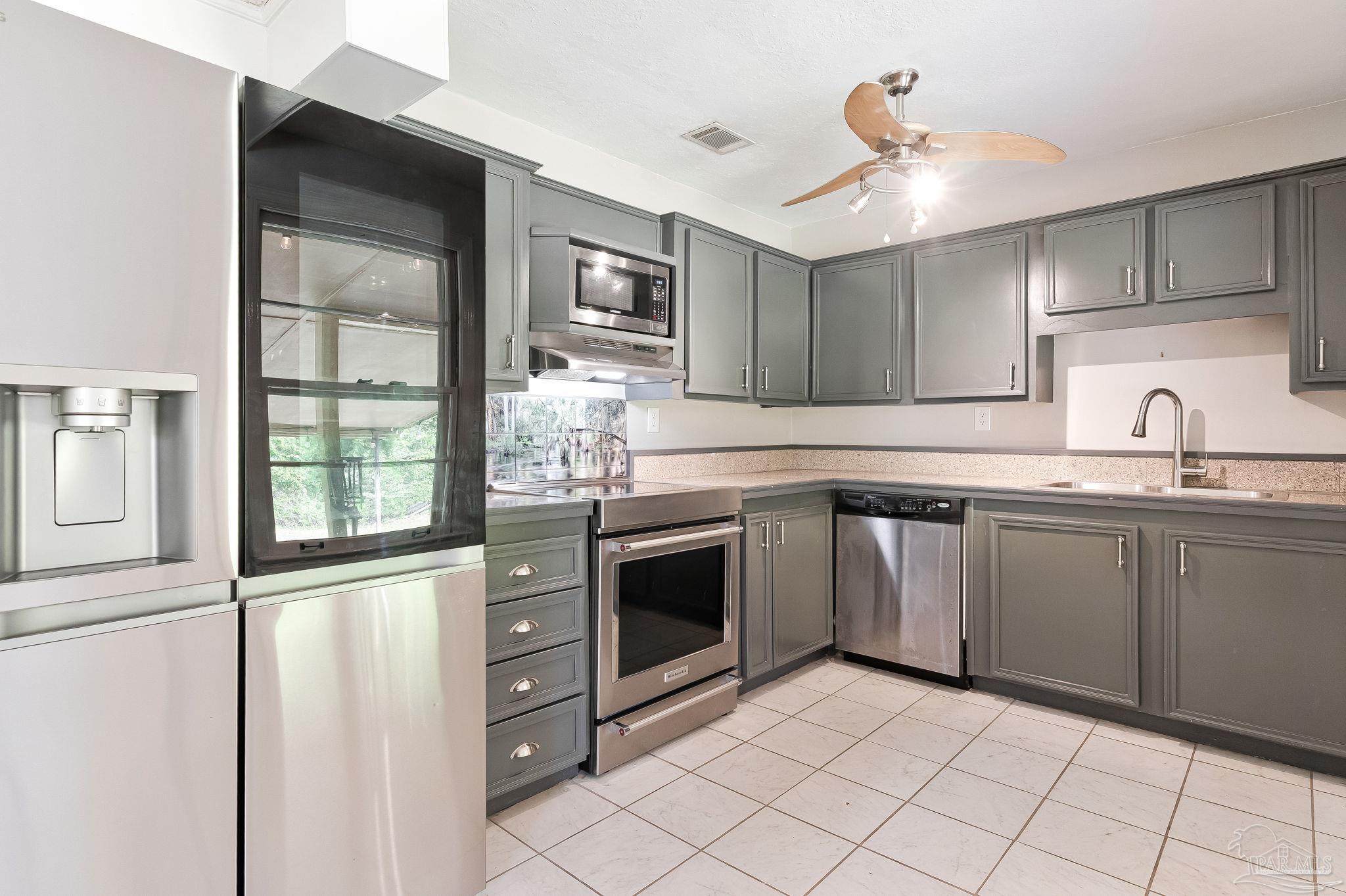 629 Rue Max Street Pensacola, FL 32507 - Photo 12 of 28 a kitchen with granite countertop a sink stainless steel appliances and cabinets