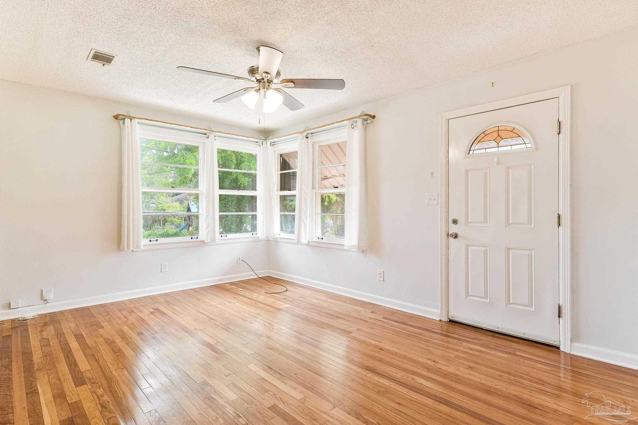 629 Rue Max Street Pensacola, FL 32507 - Photo 9 of 28 a view of an empty room with wooden floor and a window