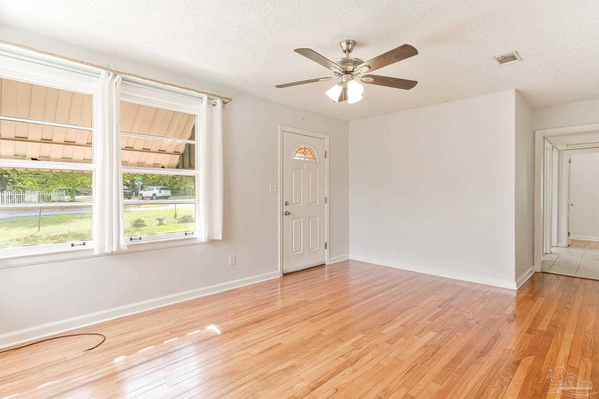629 Rue Max Street Pensacola, FL 32507 - Photo 10 of 28 a view of an empty room with wooden floor and a window