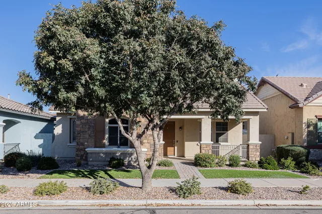 a front view of a house with a yard and potted plants