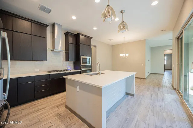 a large kitchen with a sink a counter space stainless steel appliances and cabinets