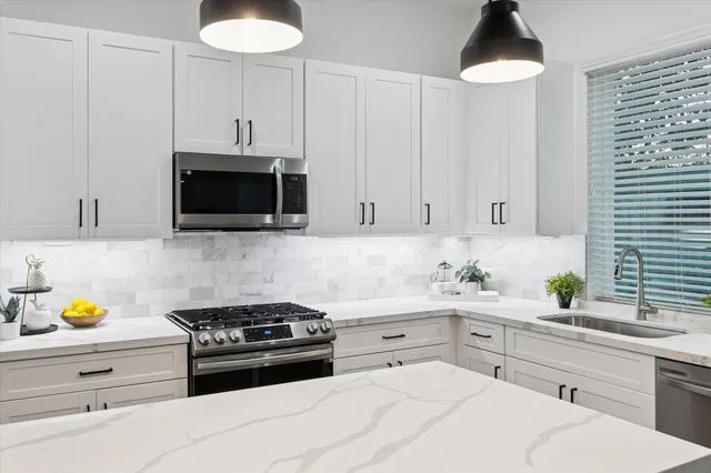 a kitchen with stainless steel appliances white cabinets and a stove a oven with wooden floor