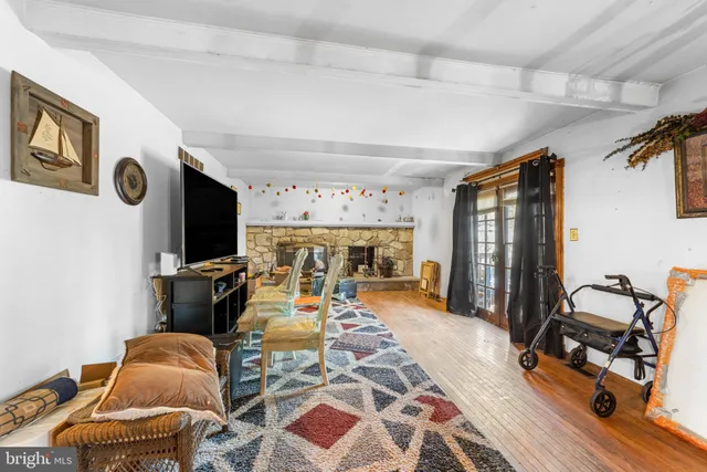 a living room with furniture a flat screen tv and gym equipment