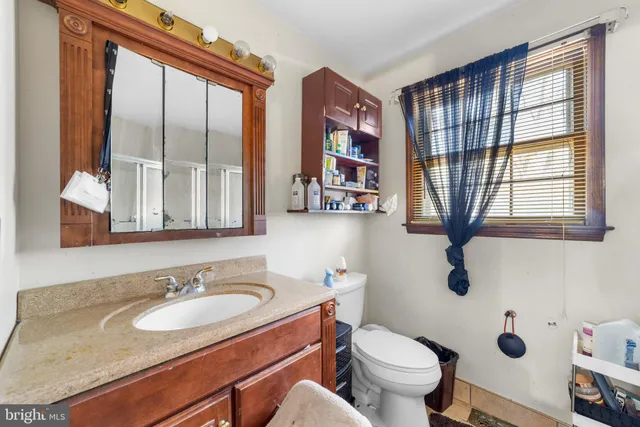 a bathroom with a sink toilet and a mirror