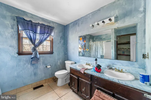 a bathroom with a sink mirror and a toilet