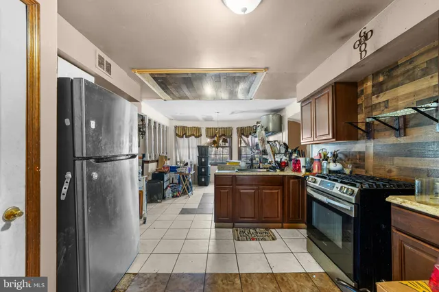 a kitchen with stainless steel appliances granite countertop a refrigerator a stove and a sink