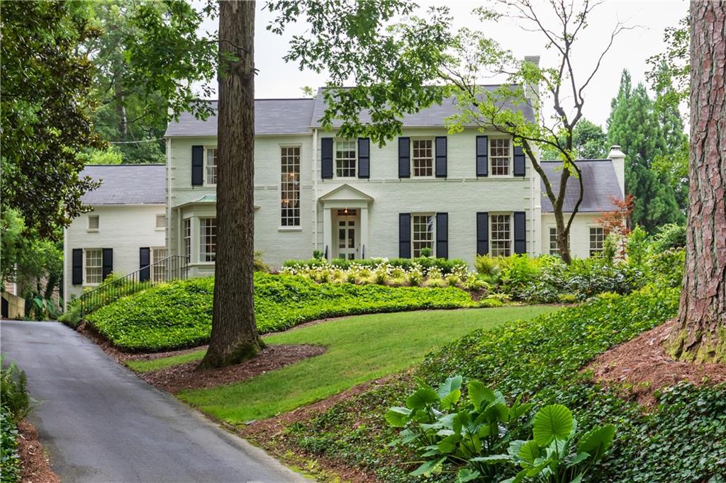 a front view of a house with a yard and trees