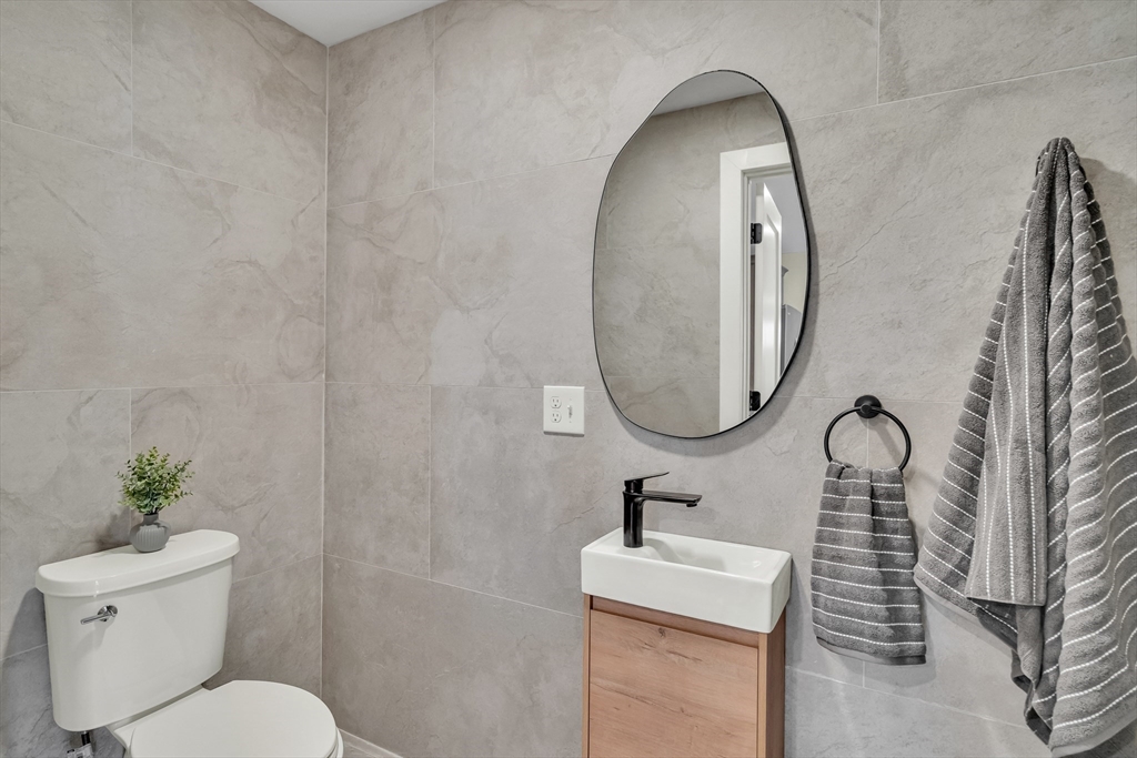 56 Riverview Street Dedham, MA 02026 - Photo 19 of 29 a bathroom with a toilet sink and mirror