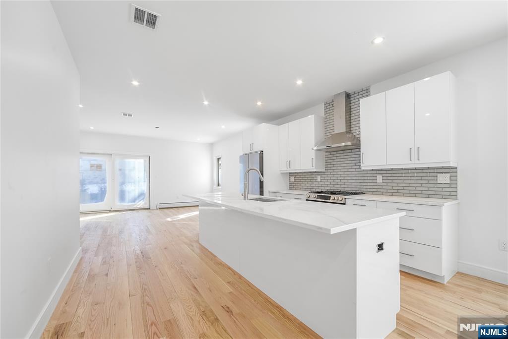 762 Williams Place, Unit A Cliffside Park, NJ 07010 - Photo 12 of 30 a kitchen with stainless steel appliances a white stove top oven sink and cabinets