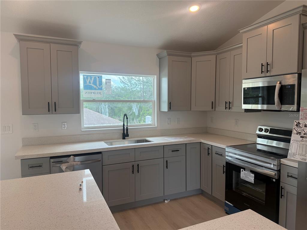 12847 Southwest 84th Terrace Road Ocala, FL 34473 - Photo 3 of 16 a kitchen with a sink stove and microwave