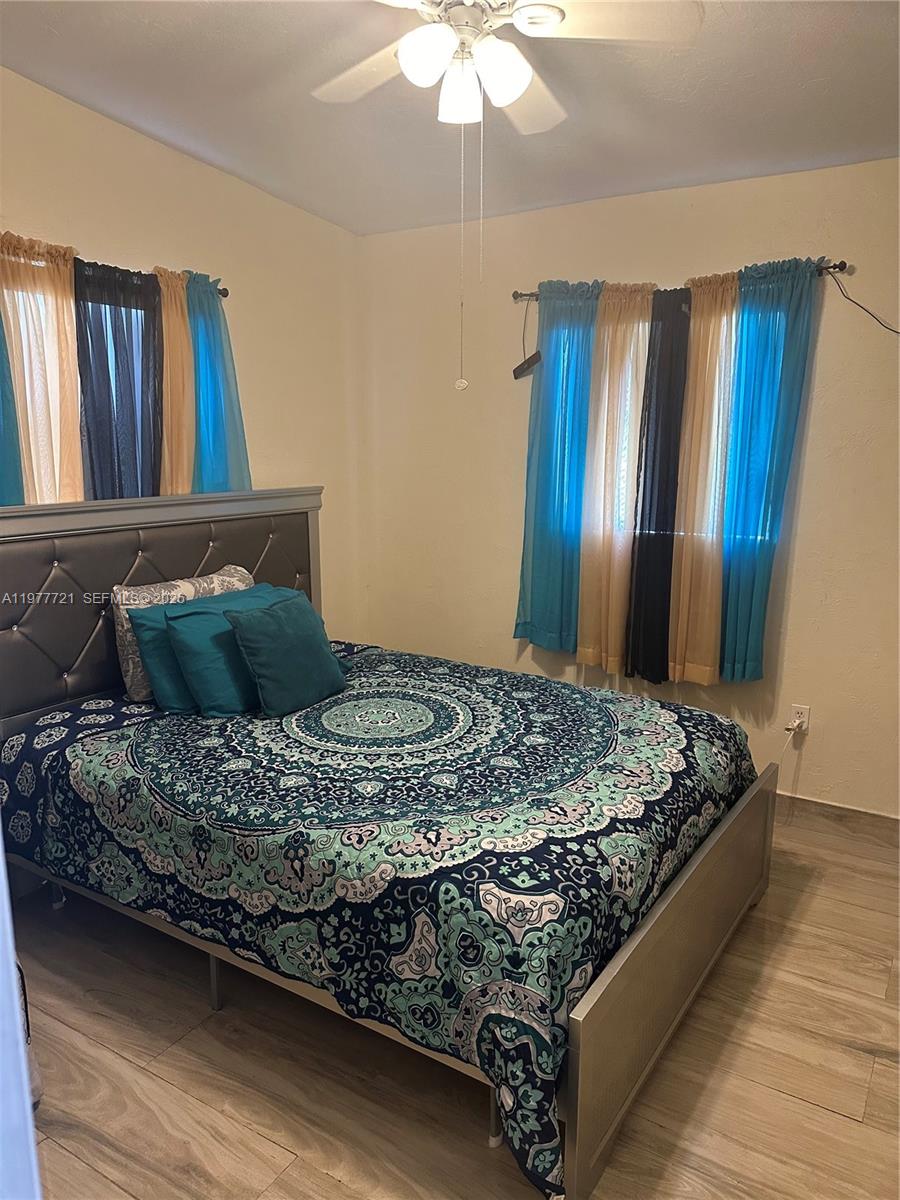 10761 Southwest 221st Street Miami, FL 33170 - Photo 13 of 32 a bed sitting in a bedroom next to a window
