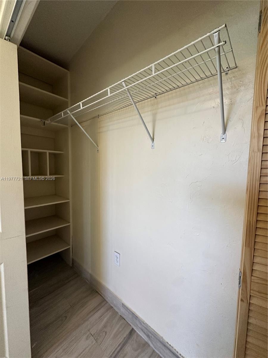 10761 Southwest 221st Street Miami, FL 33170 - Photo 14 of 32 a view of walk in closet with empty racks