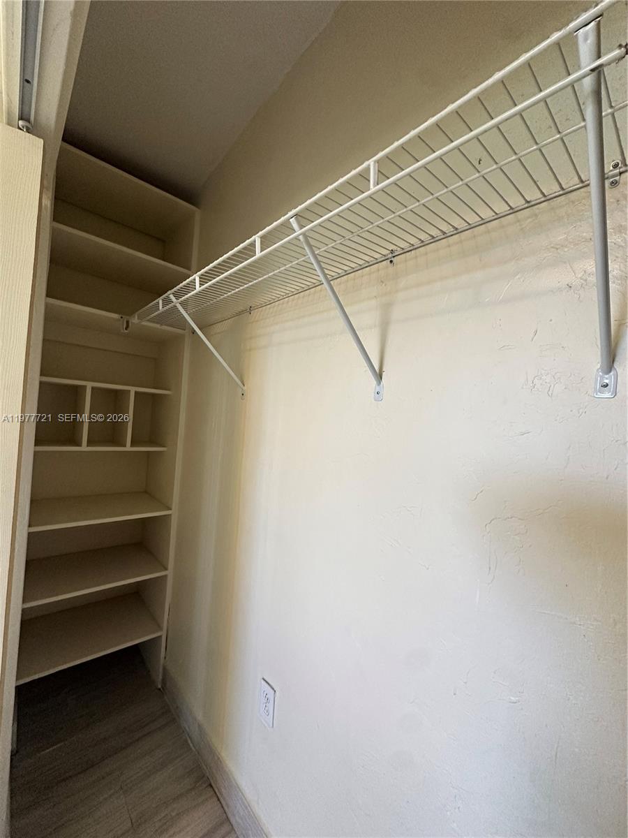 10761 Southwest 221st Street Miami, FL 33170 - Photo 15 of 32 a view of walk in closet with empty racks