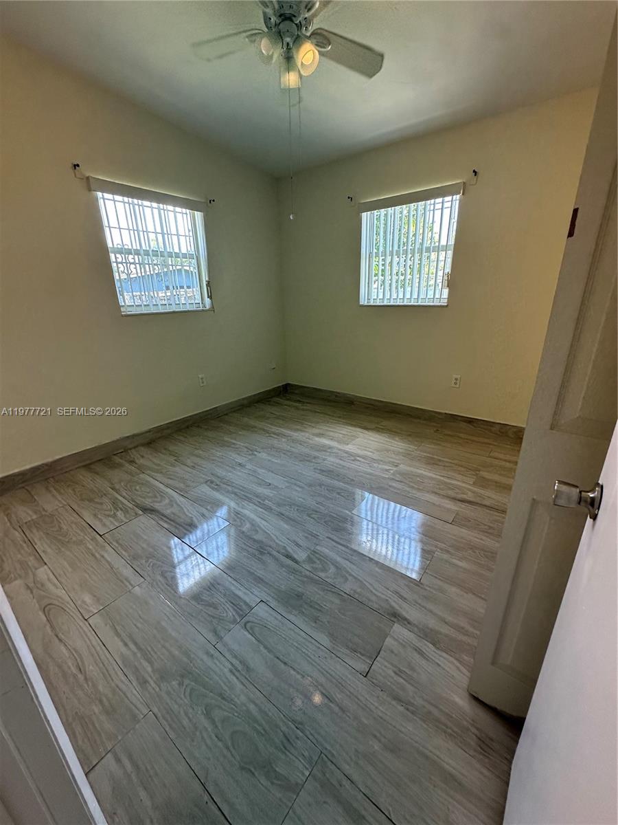 10761 Southwest 221st Street Miami, FL 33170 - Photo 20 of 32 an empty room with wooden floor and windows