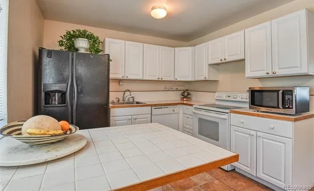 a kitchen with a refrigerator and white cabinets