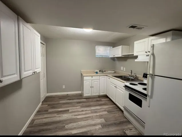 a kitchen with white cabinets and white appliances
