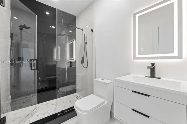 a bathroom with a sink a toilet and shower