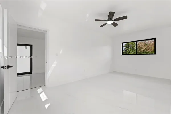 an empty room with closet and windows