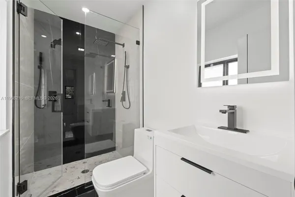 a bathroom with a sink a toilet and shower