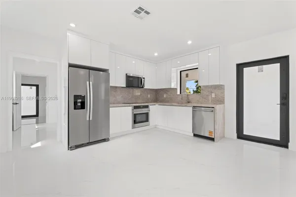 a kitchen with a refrigerator sink and cabinets