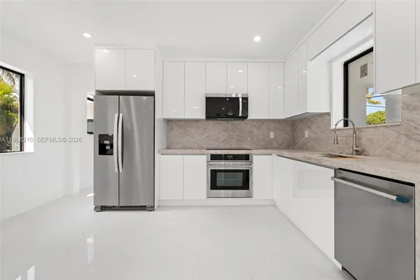 a kitchen with stainless steel appliances granite countertop a refrigerator and a stove top oven