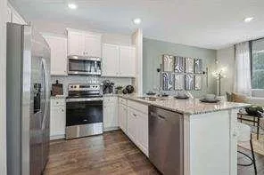 a kitchen with stainless steel appliances a sink cabinets and a refrigerator