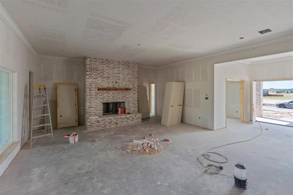 1300 Promised Land Road Hewitt, TX 76643 - Photo 34 of 34 Brick fireplace with wood mantel, crown molding, and an expansive window