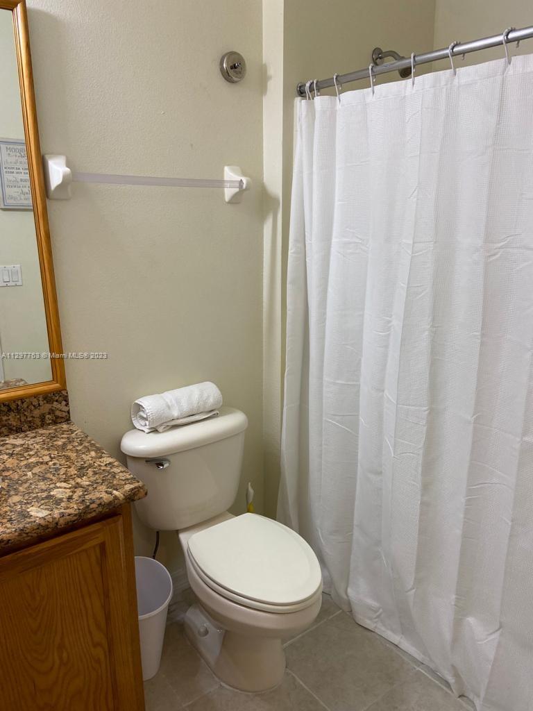 8570 Bay Lilly Loop Kissimmee, FL 34747 - Photo 12 of 36 a white toilet sitting next to a shower curtain