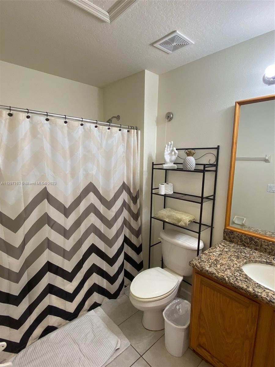 8570 Bay Lilly Loop Kissimmee, FL 34747 - Photo 23 of 36 a bathroom with a sink a toilet and shower