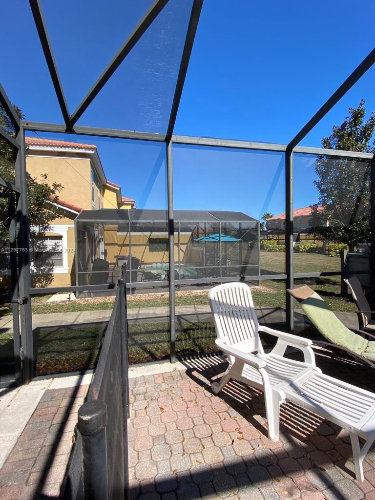 8570 Bay Lilly Loop Kissimmee, FL 34747 - Photo 24 of 36 a view of a roof deck with couches under an umbrella